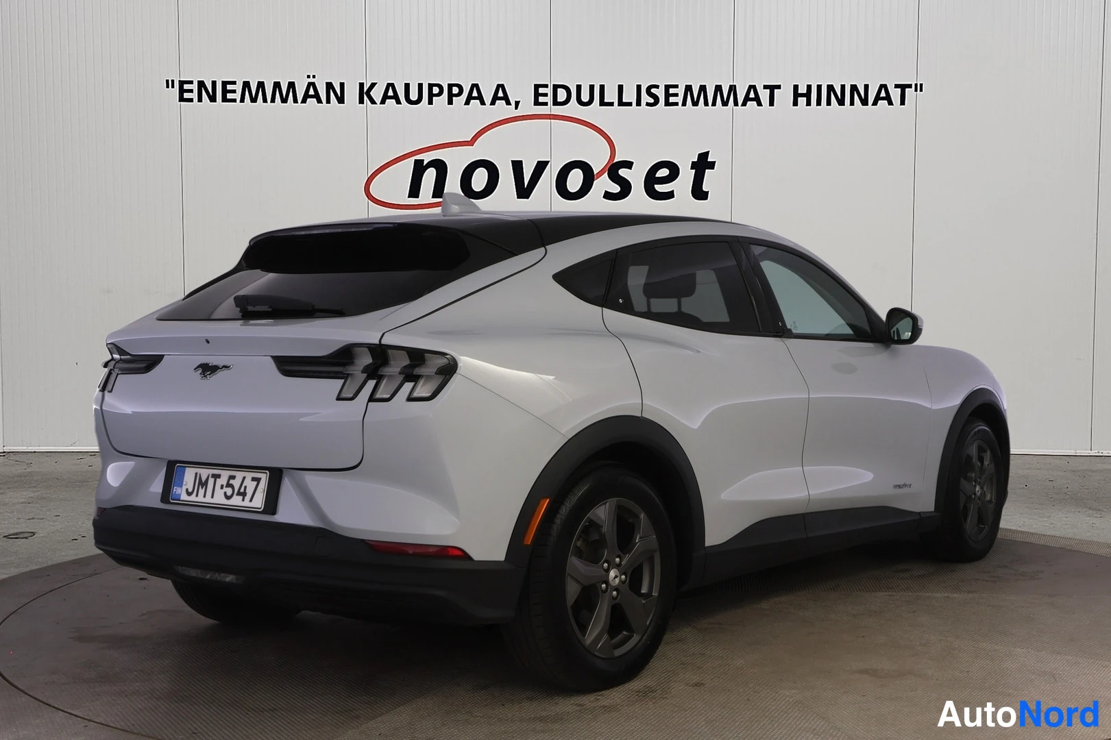 Takaviisto: Valkoisen Ford Mustang Mach-E:n takakulmanäkymä oikealta, musta katto, rekisteritunnus.
