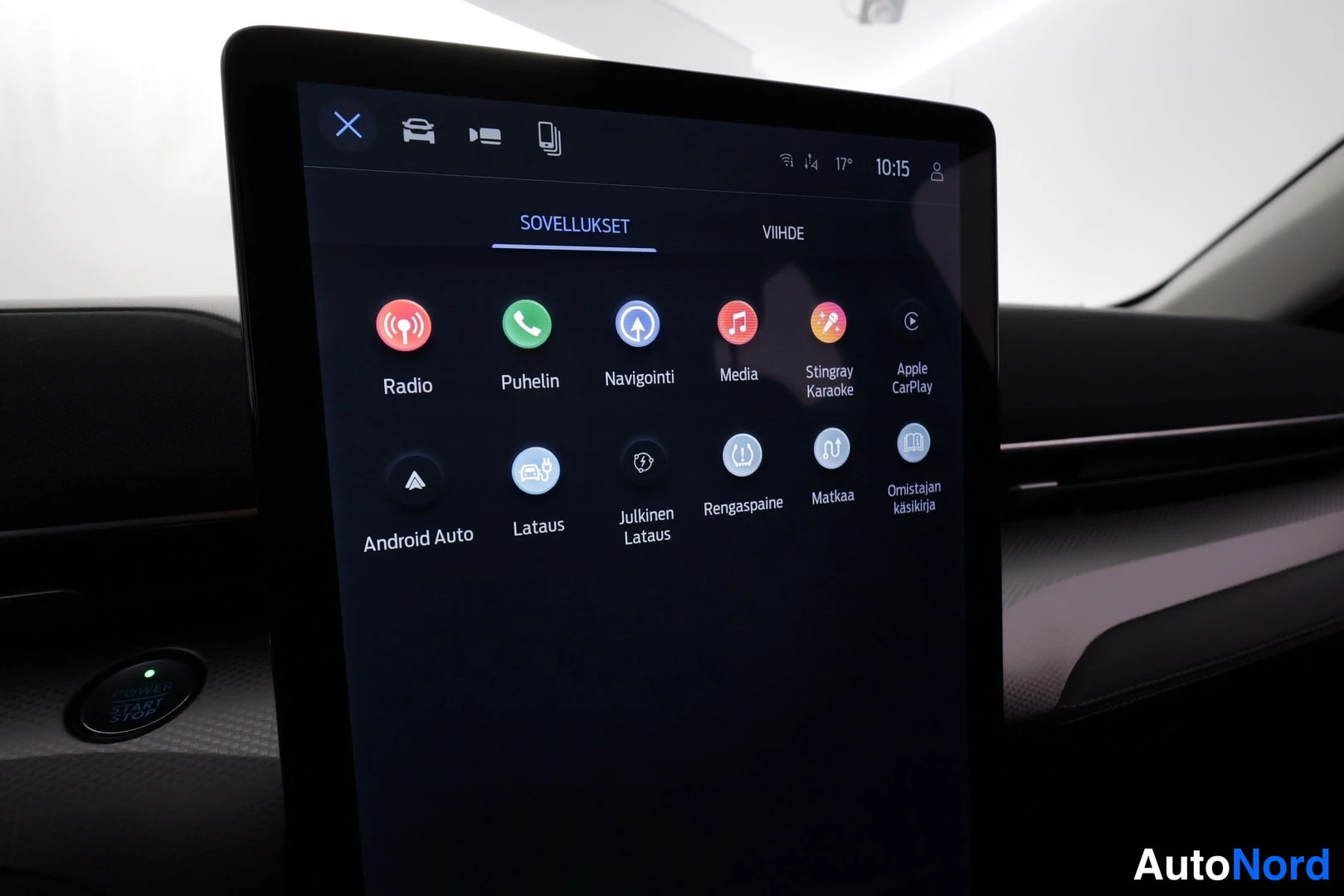 Muu: Auton keskikäyttöliittymän näyttö, jossa SOVELLUKSET-näkymä: Radio, Puhelin, Navigointi, Media, Apple CarPlay ja Android Auto kuvakkeina.