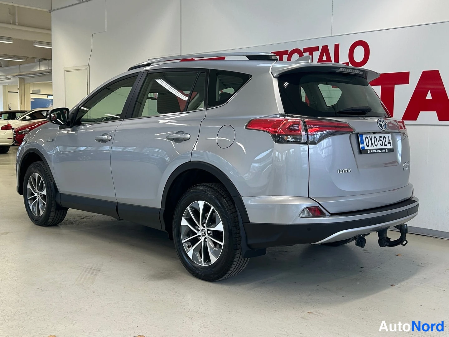 Takaviisto: Takaviistonäkymä hopeanvärisestä Toyota RAV4:stä, rekisterikilpi ja irrotettava vetokoukku näkyvissä.