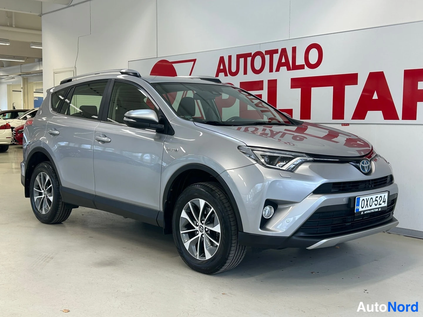 Etuviisto, nokka oikealle: Hopeanvärinen Toyota RAV4 etukulmasta oikealta kuvattuna; rekisterikilpi OX0-524 ja sumuvalot näkyvät.
