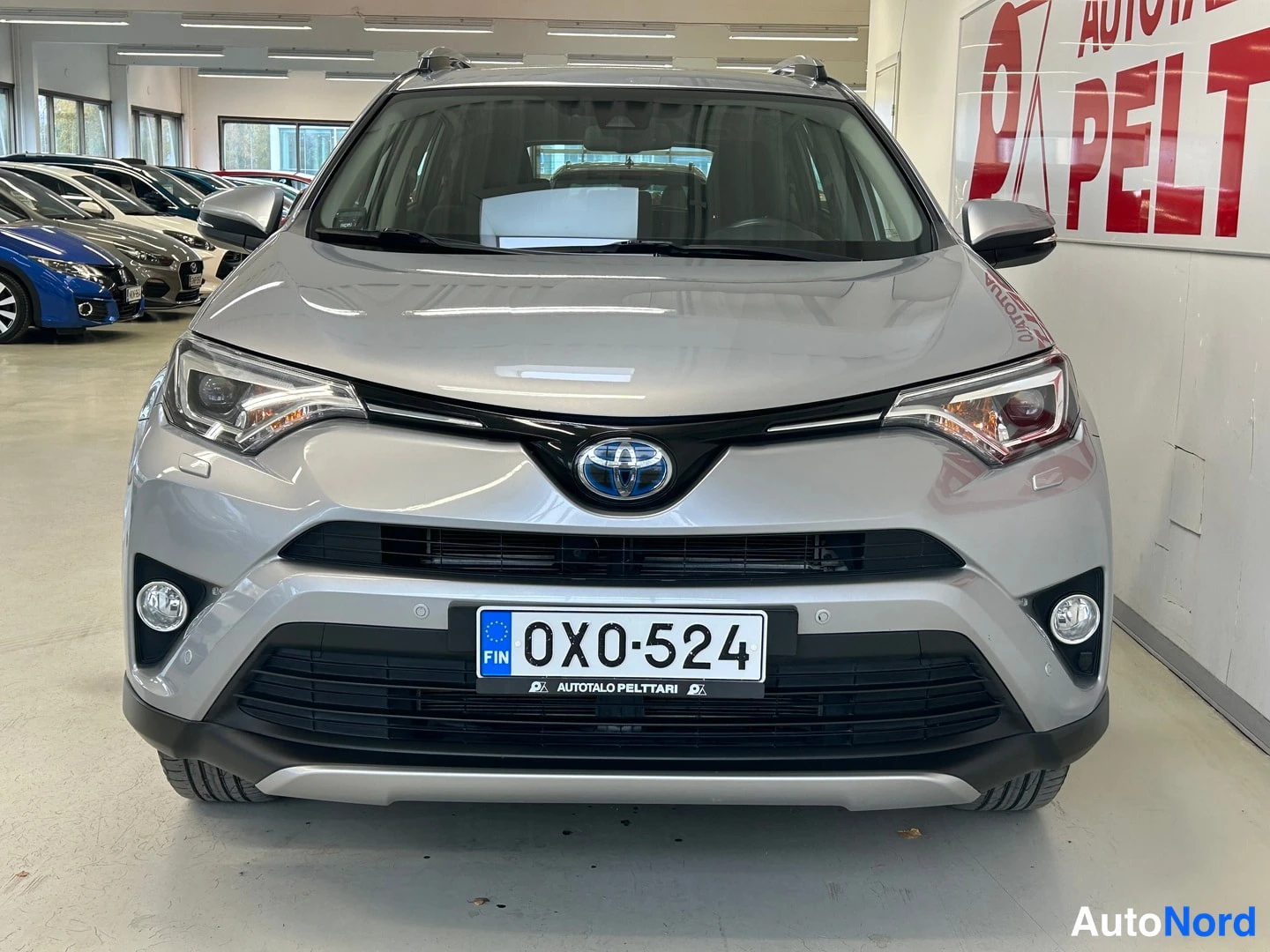 Edestä: Hopeanvärinen Toyota RAV4 suoraan edestä kuvattuna; rekisterikilpi OX0-524, sumuvalot ja Toyota-merkki näkyvät.