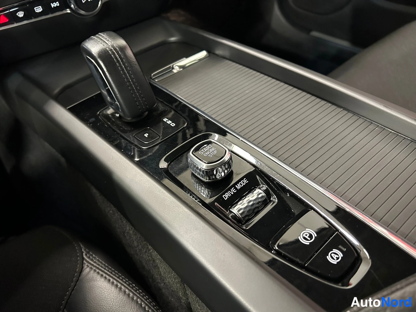 Muu: Auton keskikonsoli: vaihteenvalitsin, käynnistyspainike (START ENGINE STOP), DRIVE MODE -valitsin, sähköinen parkkijarru (P) ja Auto Hold (A).