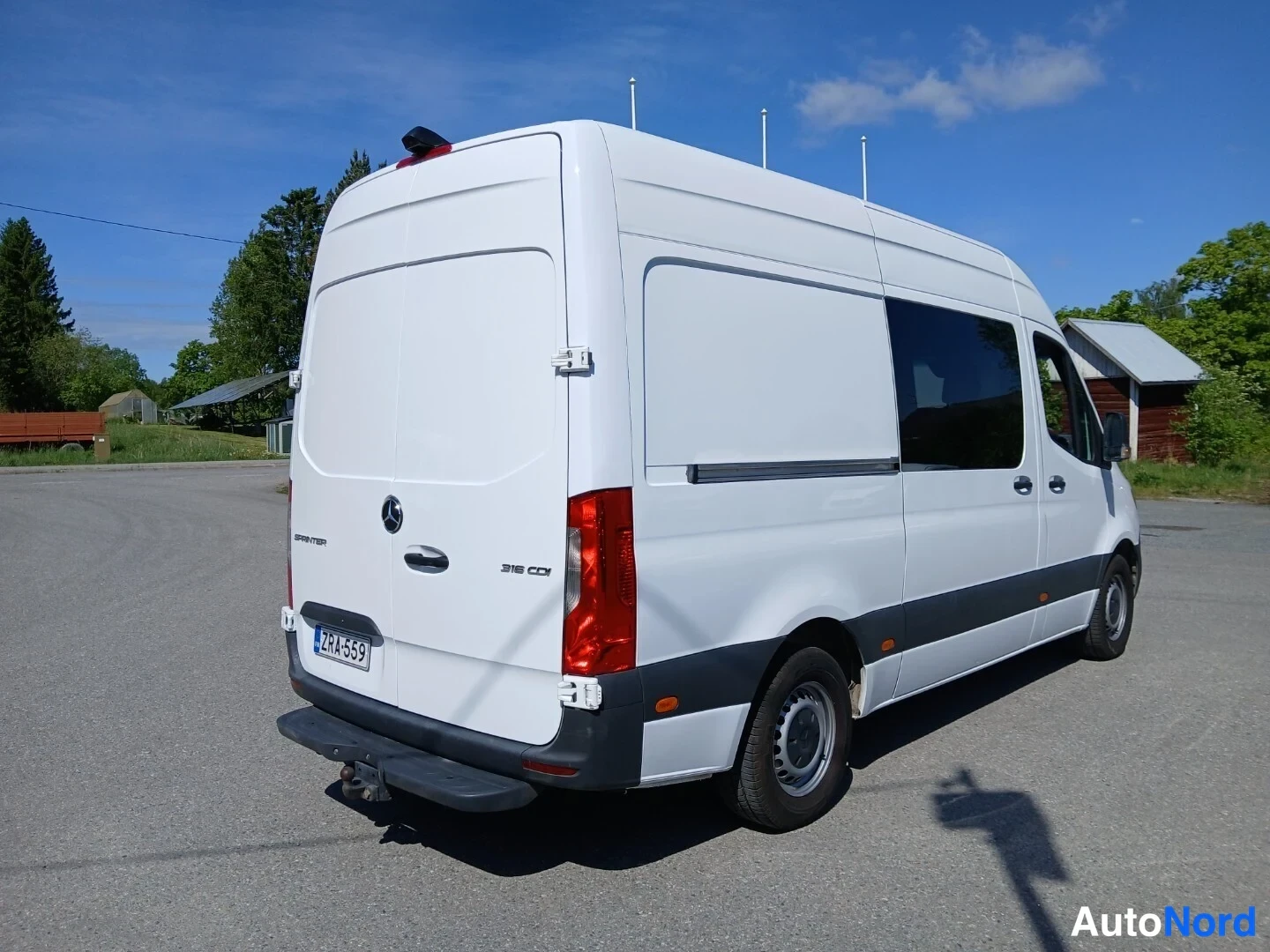 Takaviisto: Mercedes-Benz Sprinter -pakettiauto takaa kolmannelta neljännekseltä vasemmalta, 316 CDI -merkintä takaluukussa, rekisterikilpi ja vetokoulukytkin.