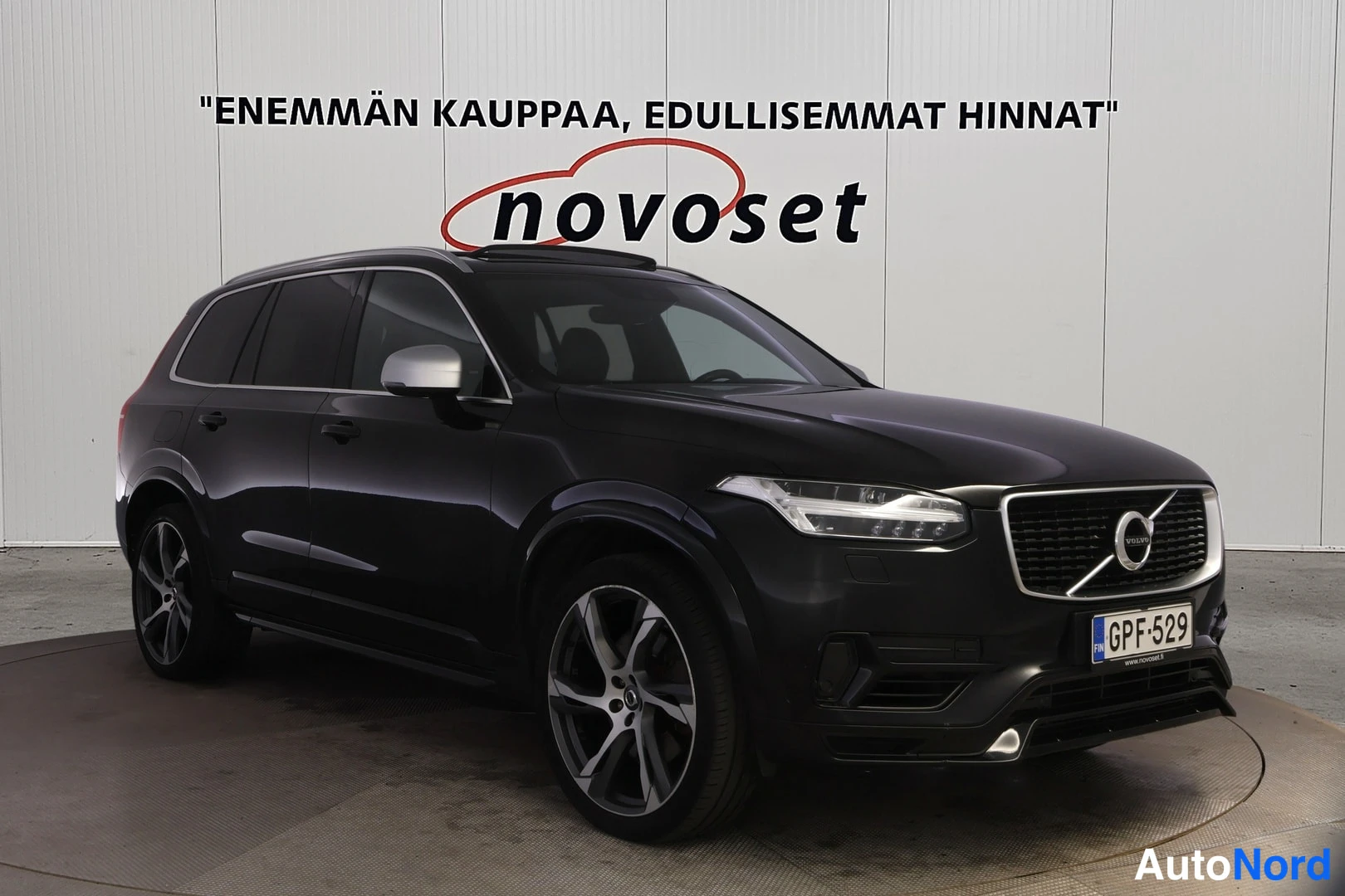 Etuviisto, nokka oikealle: Musta Volvo XC90 kulmassa edestä oikealta nähtynä, rekisteritunnus.