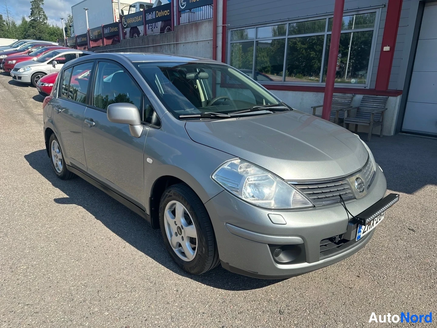 Grey Nissan Tiida 2010, front three-quarter, nose to the right, photo 3