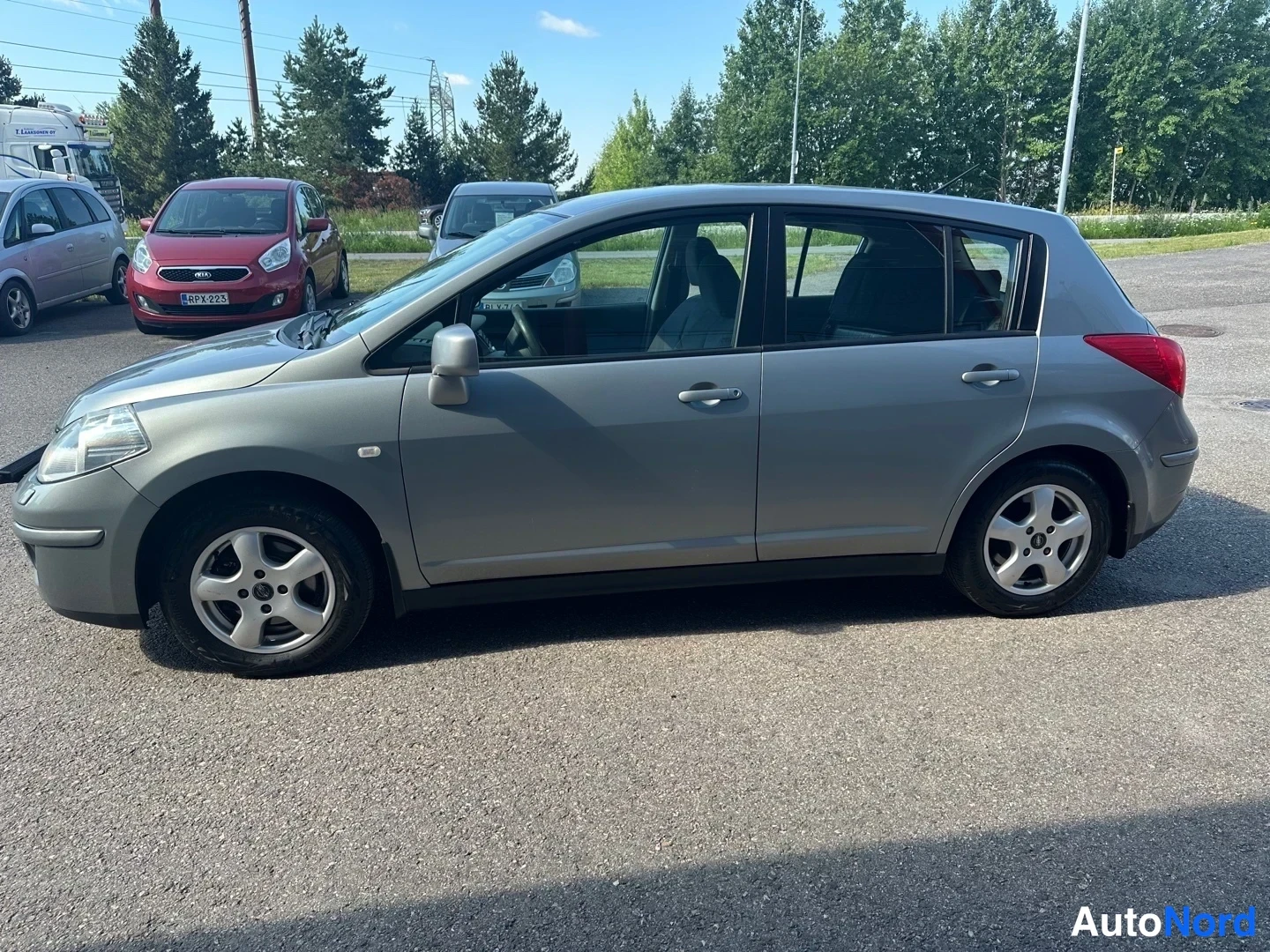 Grey Nissan Tiida 2010, front three-quarter, nose to the left, photo 2