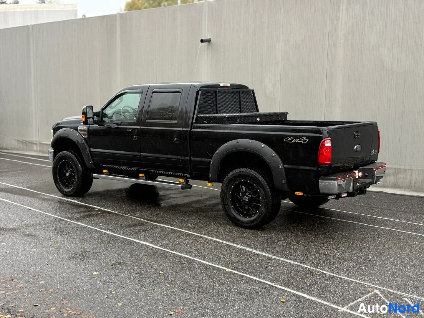 Takaviisto: Mustan pickup-avolavan takakulma oikealta; takavalot, avolava ja mustat vanteet.