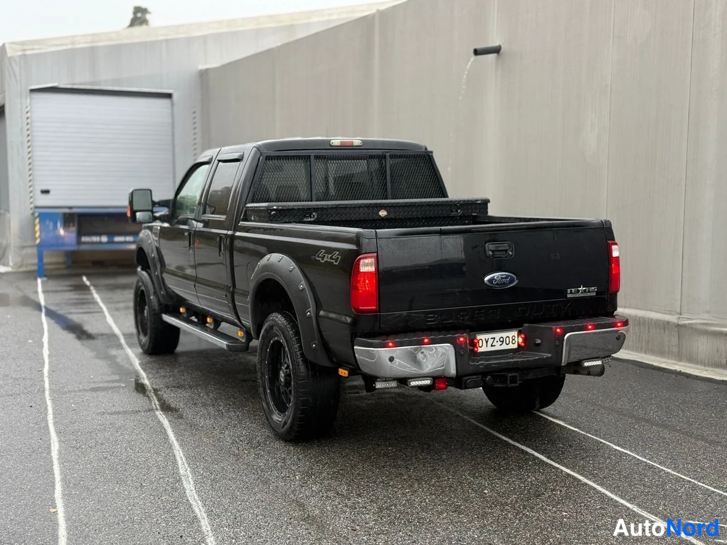 Takaa: Mustan pickup-avolavan perä suoraan takaa; Ford-merkki, takavalot, rekisterikilpi ja perävilkut.