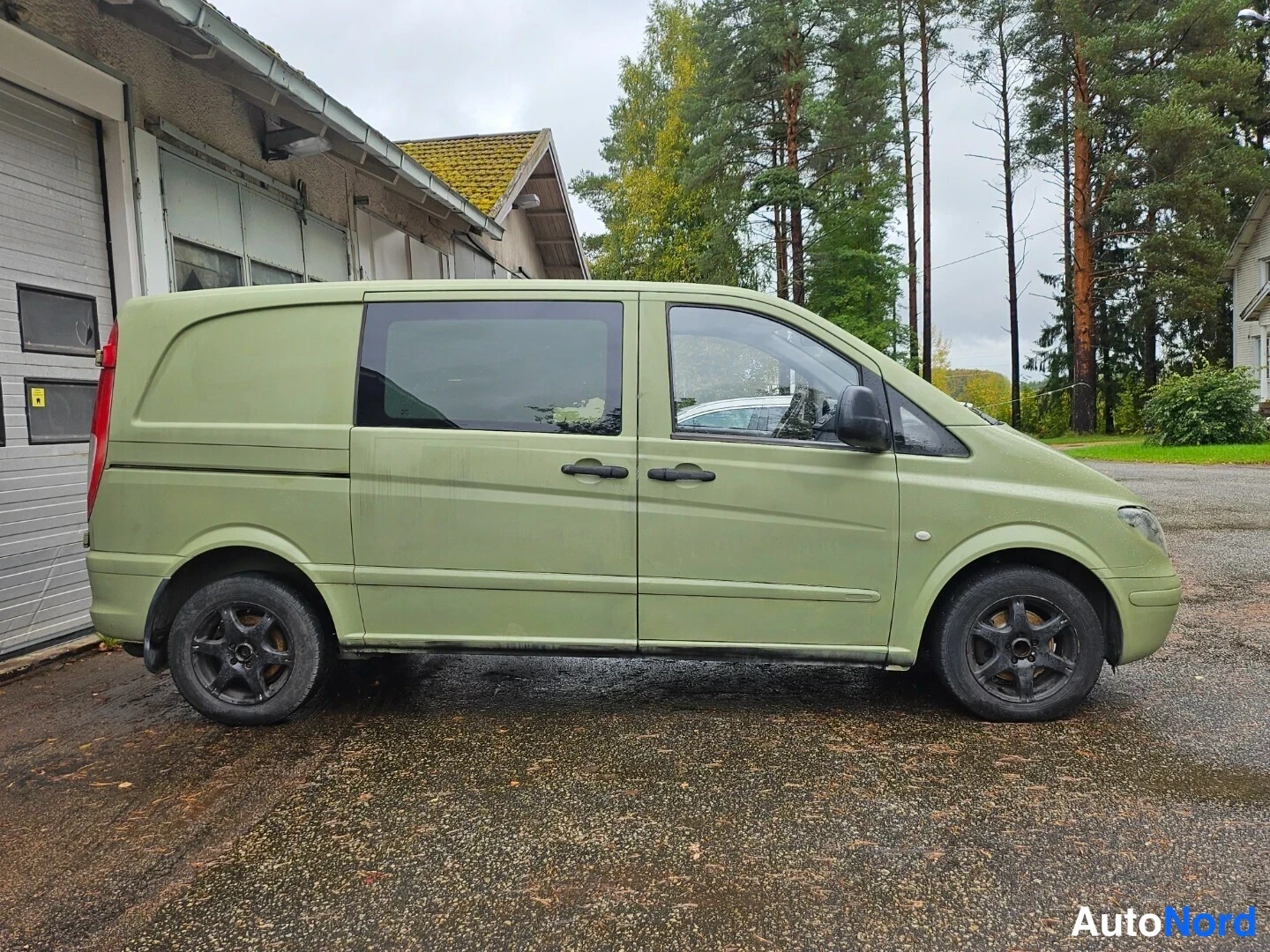 Sivulta: Vihreä Mercedes-Benz Vito -pakettiauto sivulta oikealta, takana salvatut takaovet ja kaksi sivuikkunaa.