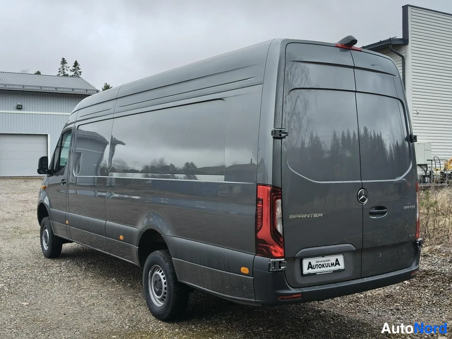Takaviisto: Mercedes-Benz Sprinter -pakettiauton takaosa ja vasen kylki kolmasosakulmasta harmaassa värissä; Mercedes-tähti ja Sprinter-teksti takaluukussa, rekisterikilpi