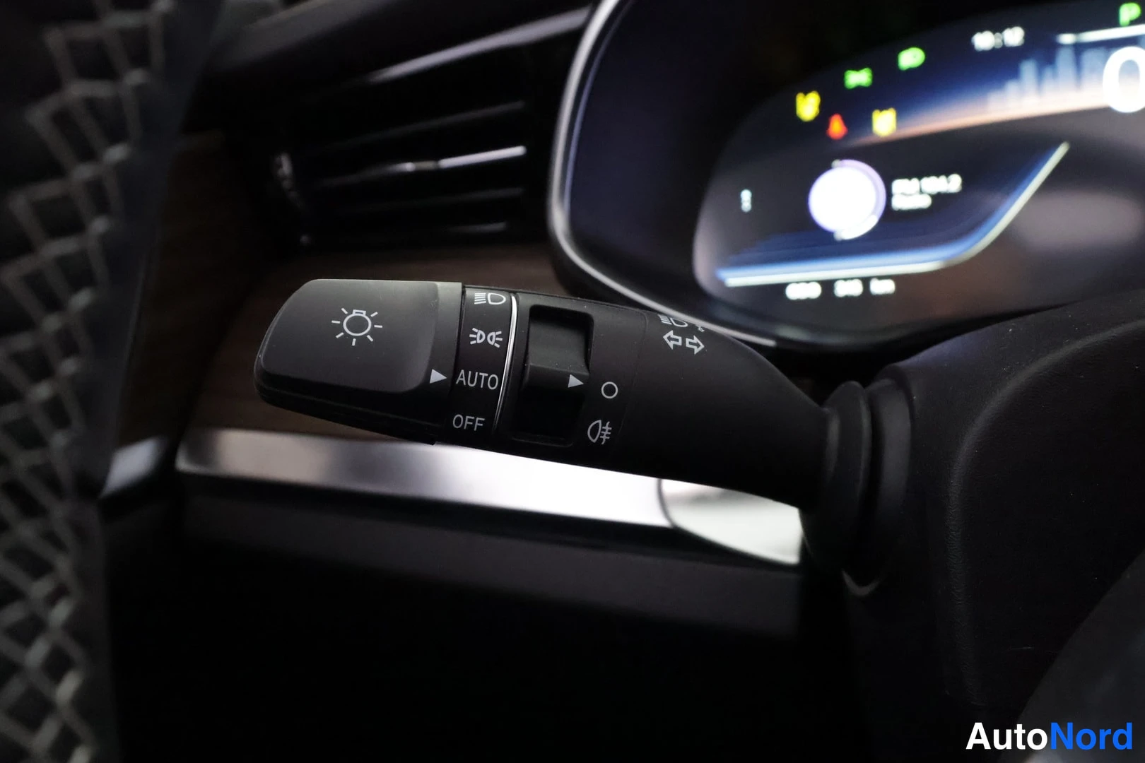 Muu: Valonsiirtimen lähikuva merkeillä OFF, AUTO ja sumuvalot; taustalla osittain näkyvä digitaalinen kojelauta.