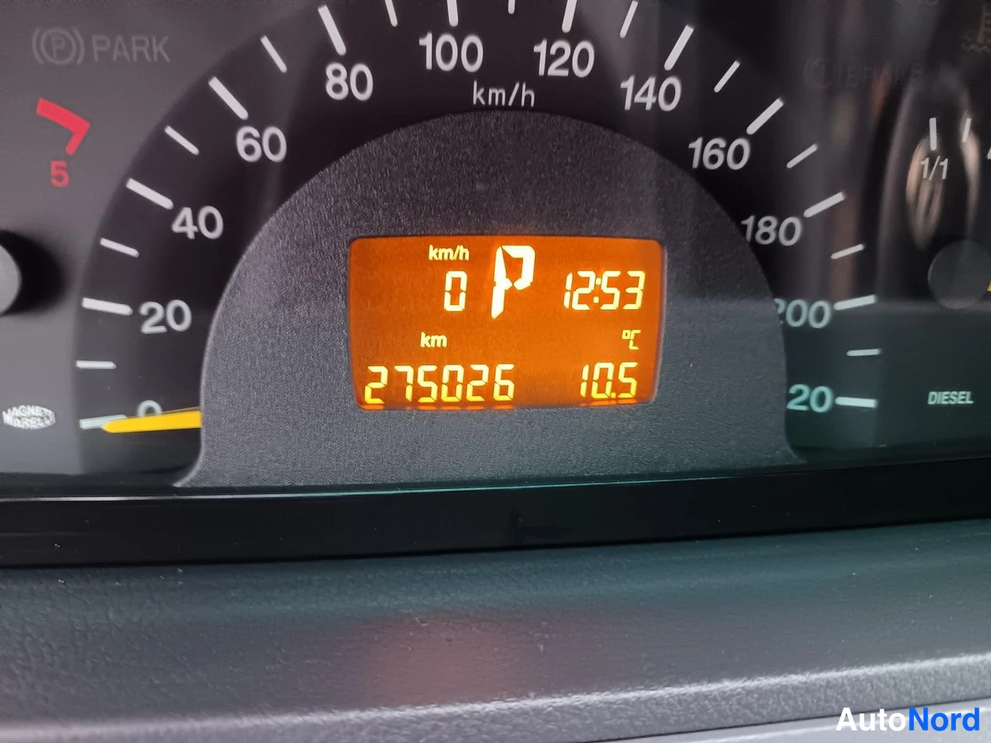 Muu: Mercedes-Benz Vito:n mittariston nopeusmittari ja oranssi näyttö, jonka lukema on 275026 km, vaihde P ja kello 12:53.