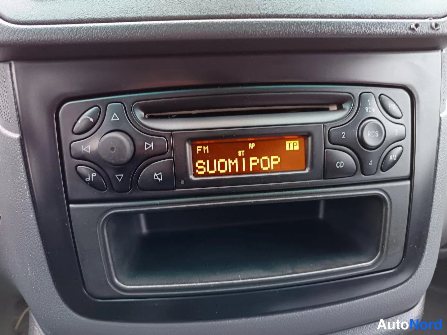 Muu: Auton radiokasetti, jolla CD-kiekko ja näyttö, jossa lukee 'SUOMIPOP' ja 'FM ST TP'.