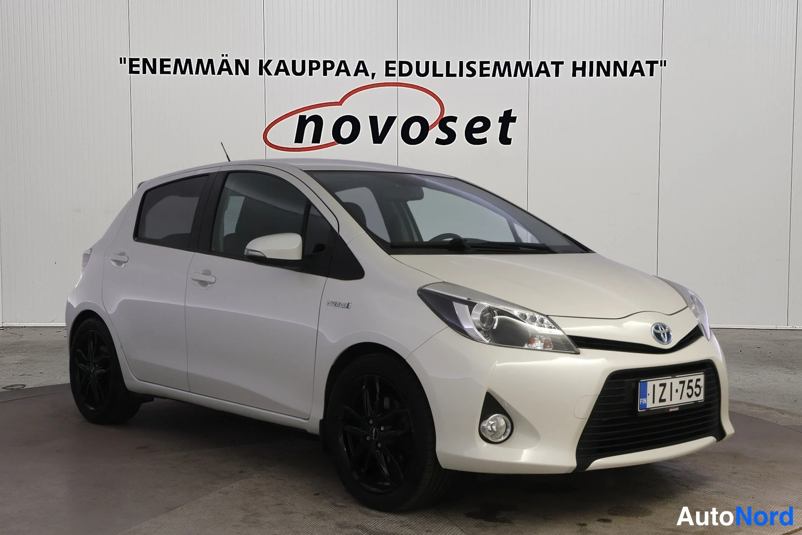 Valkoinen Toyota Yaris Hybrid 2014, etuviisto, keula oikealle, kuva 2
