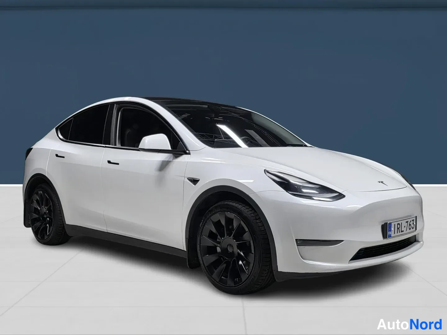White Tesla Model Y 2023, front three-quarter, nose to the right, photo 2