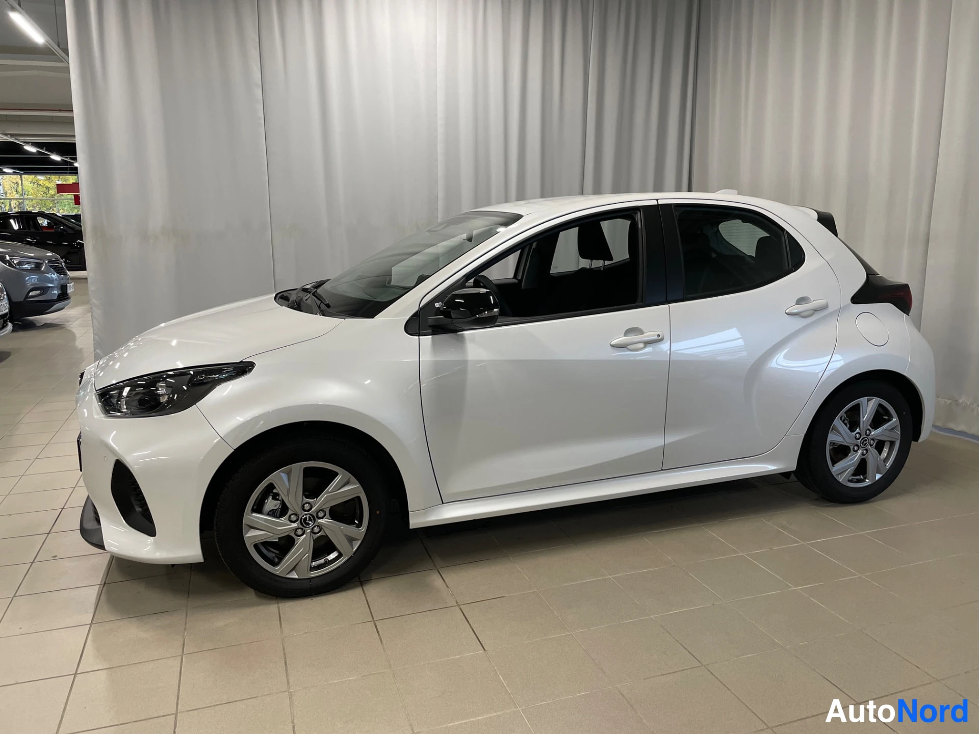 White Mazda Mazda2 Hybrid 2026, front three-quarter, nose to the left, photo 2