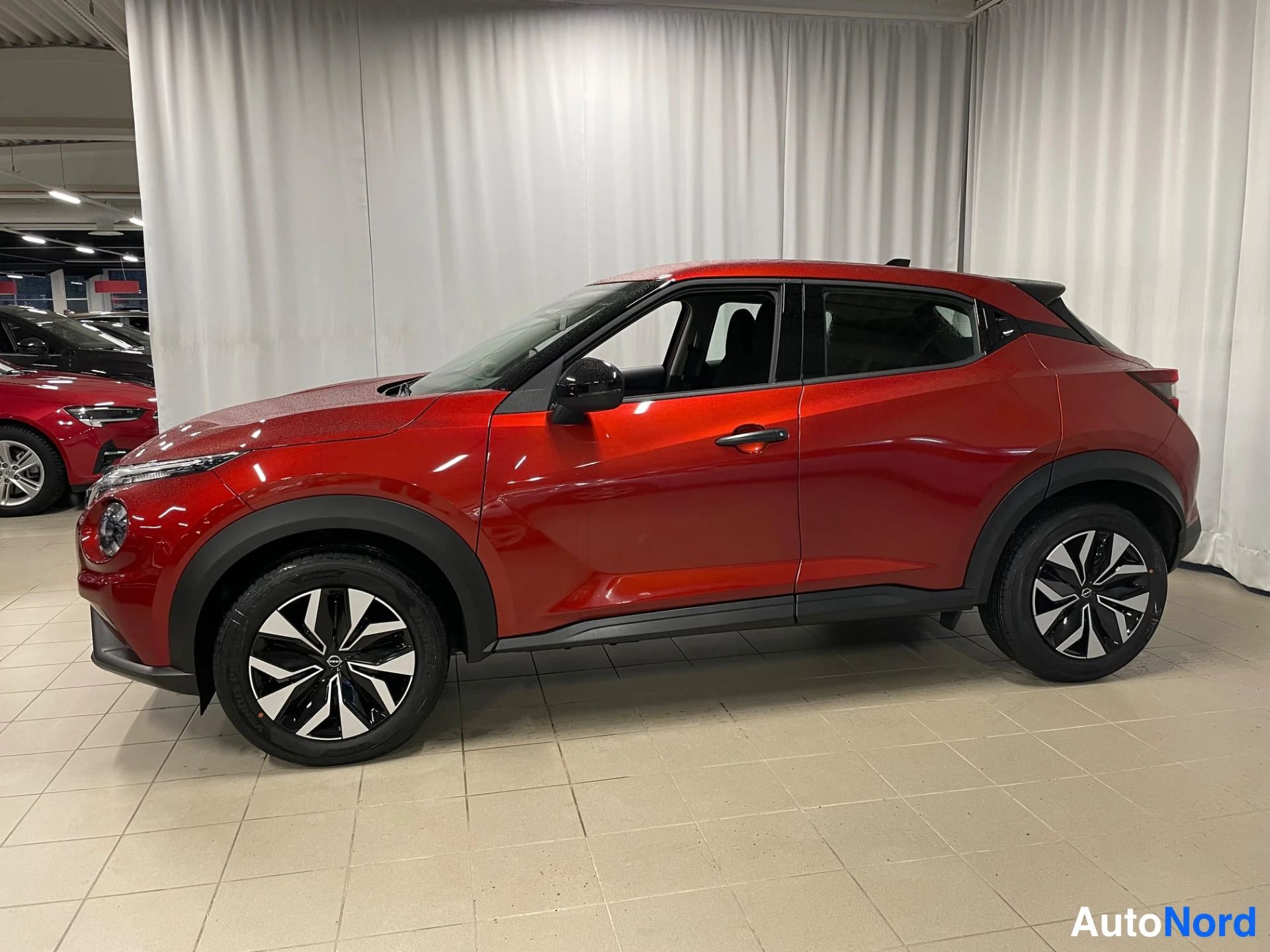 Red Nissan Juke 2026, front three-quarter, nose to the left, photo 2