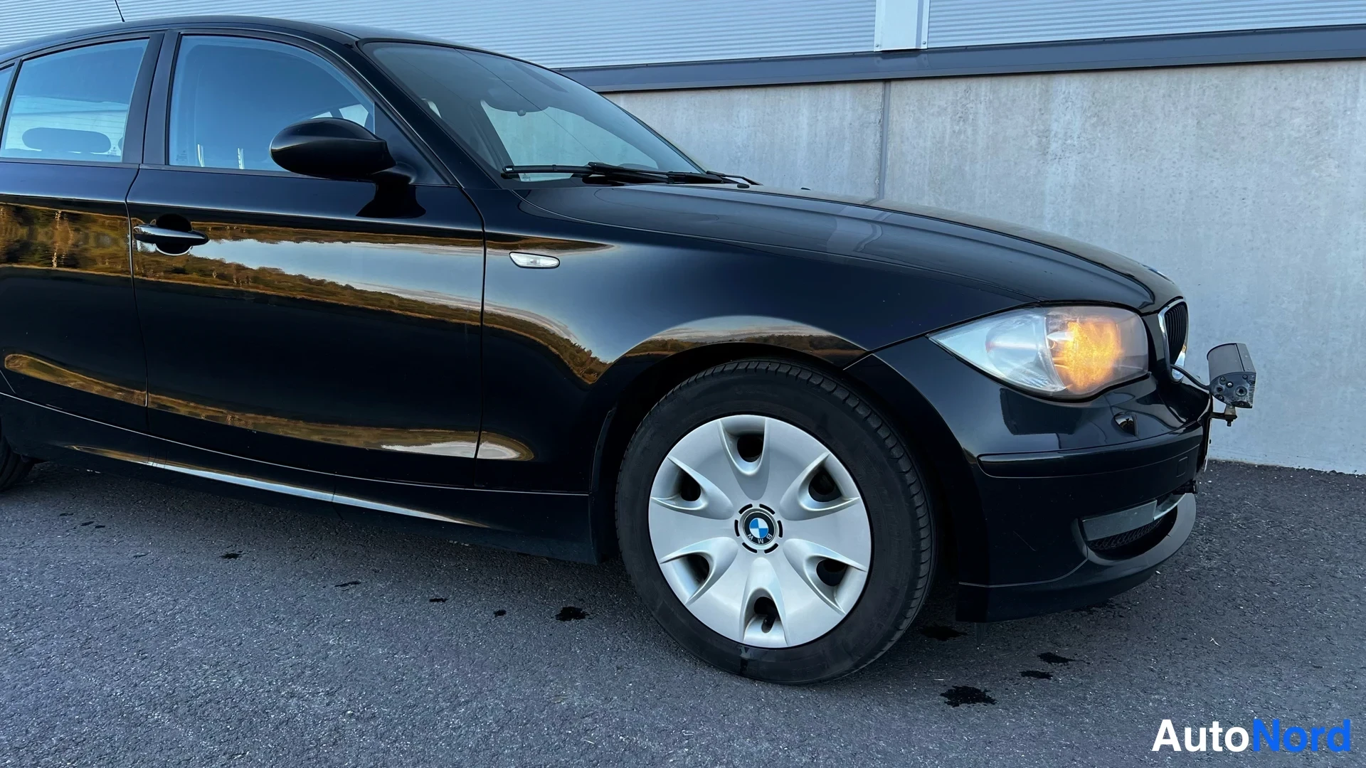 Black BMW 116i 2009, front three-quarter, nose to the right, photo 6