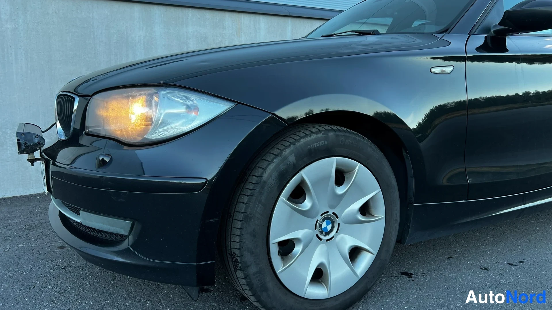 Black BMW 116i 2009, front three-quarter, nose to the left, photo 2