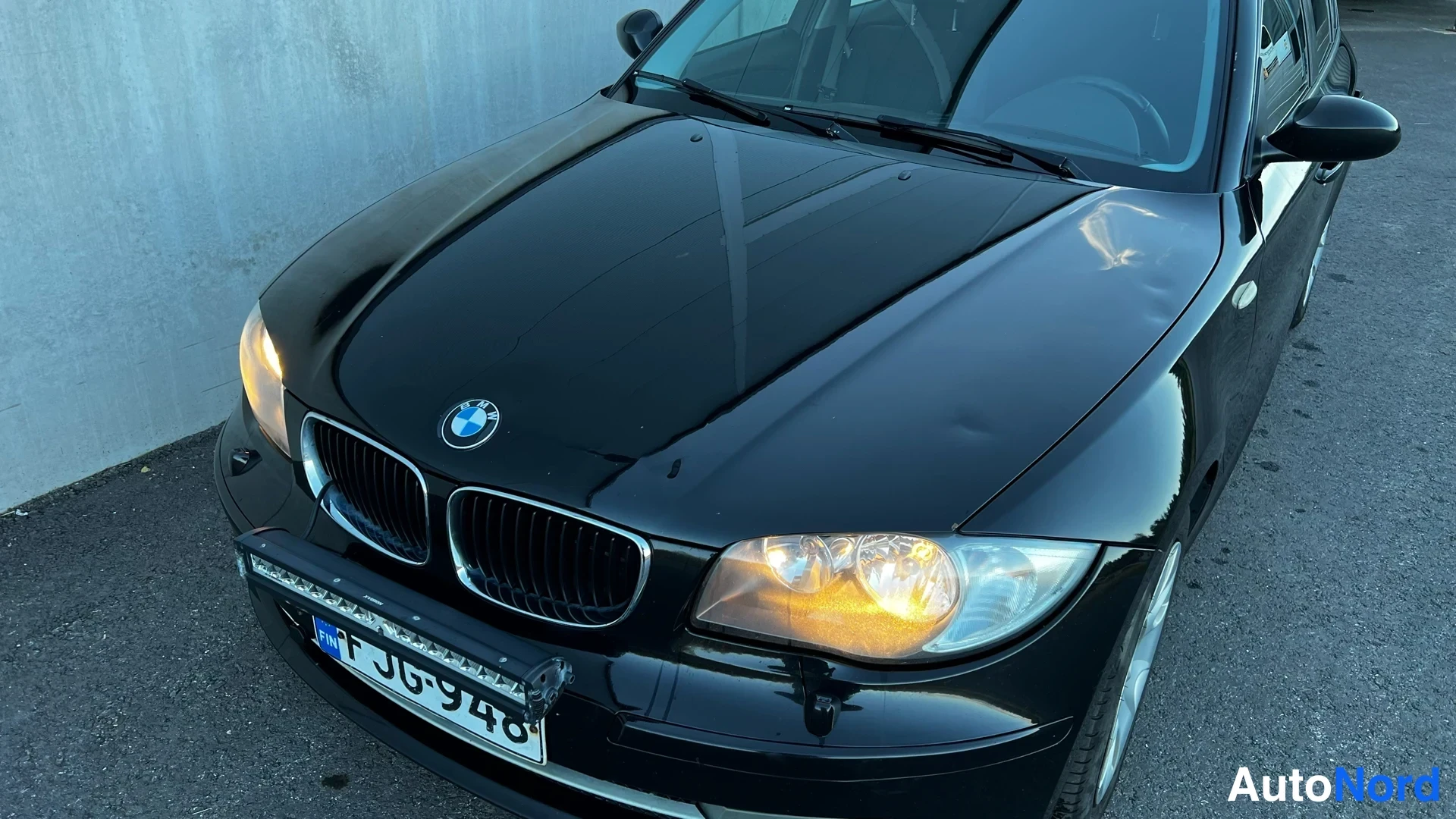 Black BMW 116i 2009, front three-quarter, nose to the left, photo 3