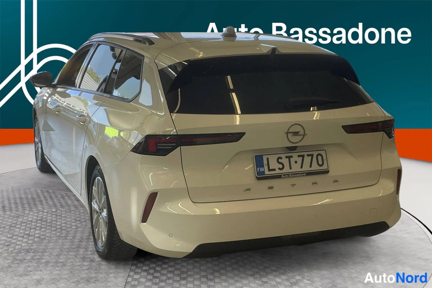 Vit Opel Astra Sports Tourer 2024, snett bakifrån, bild 8