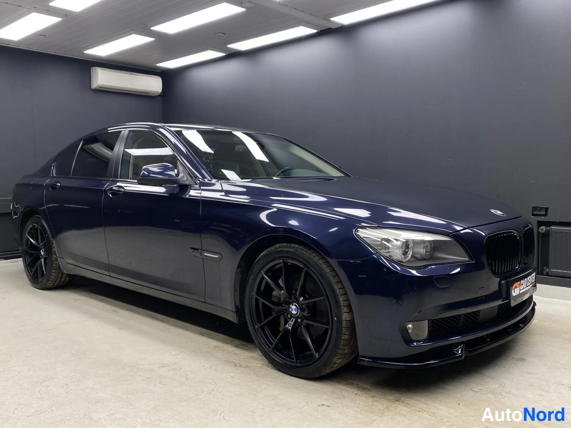 Blå BMW 740d xDrive 2013, snett framifrån, fronten åt höger, bild 2