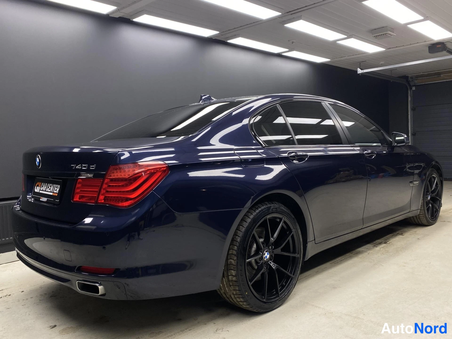 Blå BMW 740d xDrive 2013, snett bakifrån, bild 5