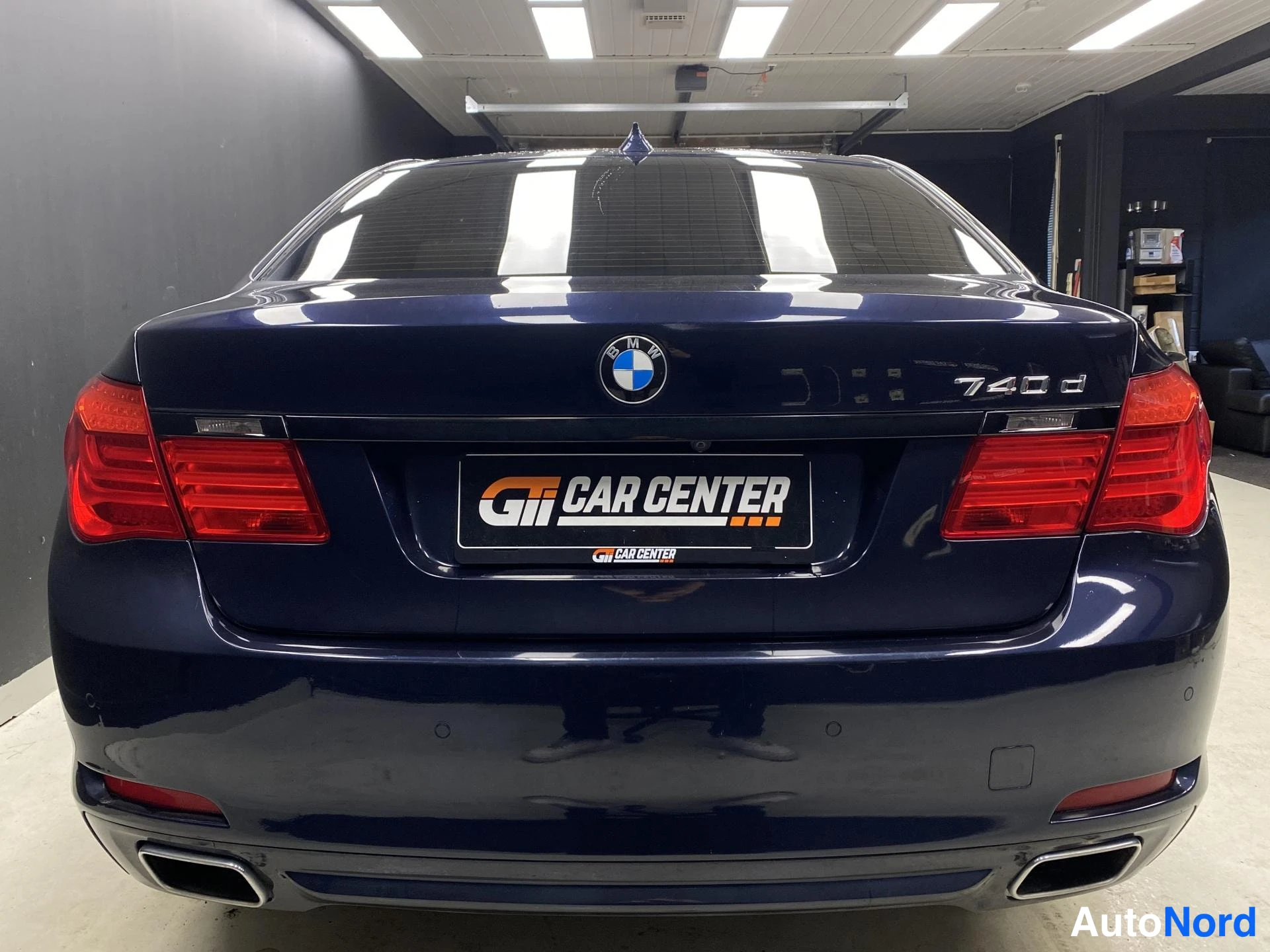 Blå BMW 740d xDrive 2013, bakifrån, bild 6