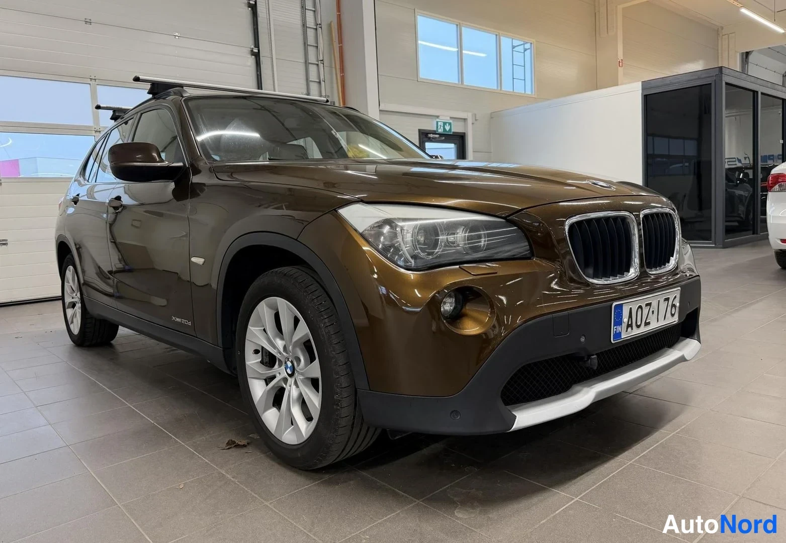 Ruskea BMW X1 2010, etuviisto, keula oikealle, kuva 2