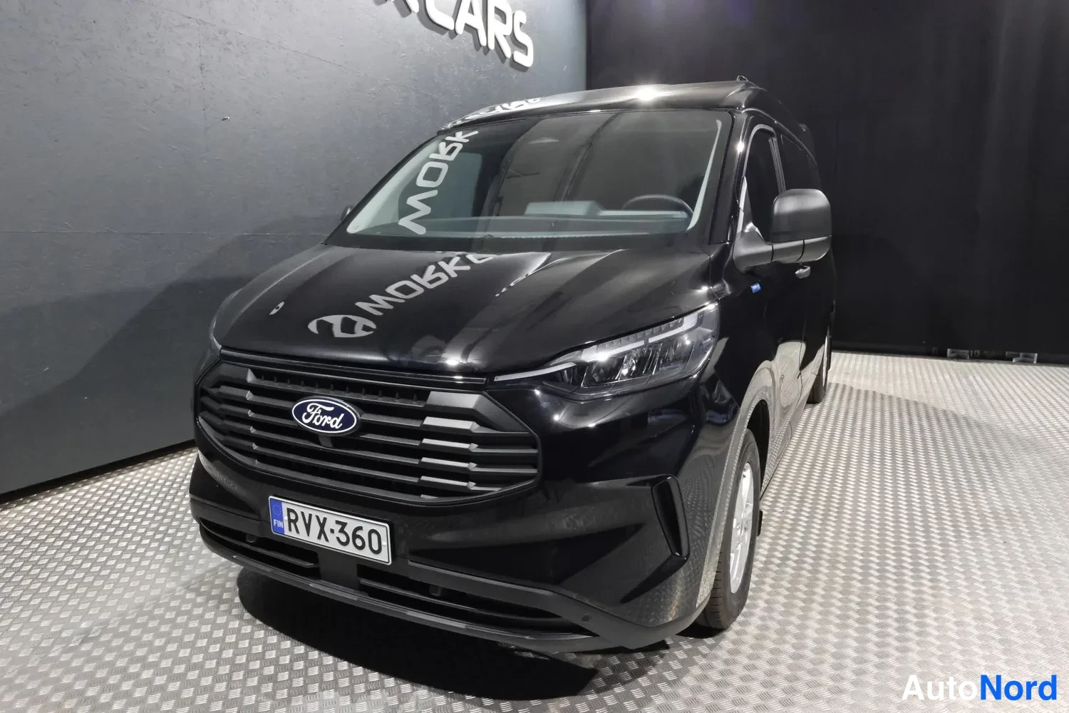 Svart Ford Transit Custom 2025, snett framifrån, fronten åt vänster, bild 3
