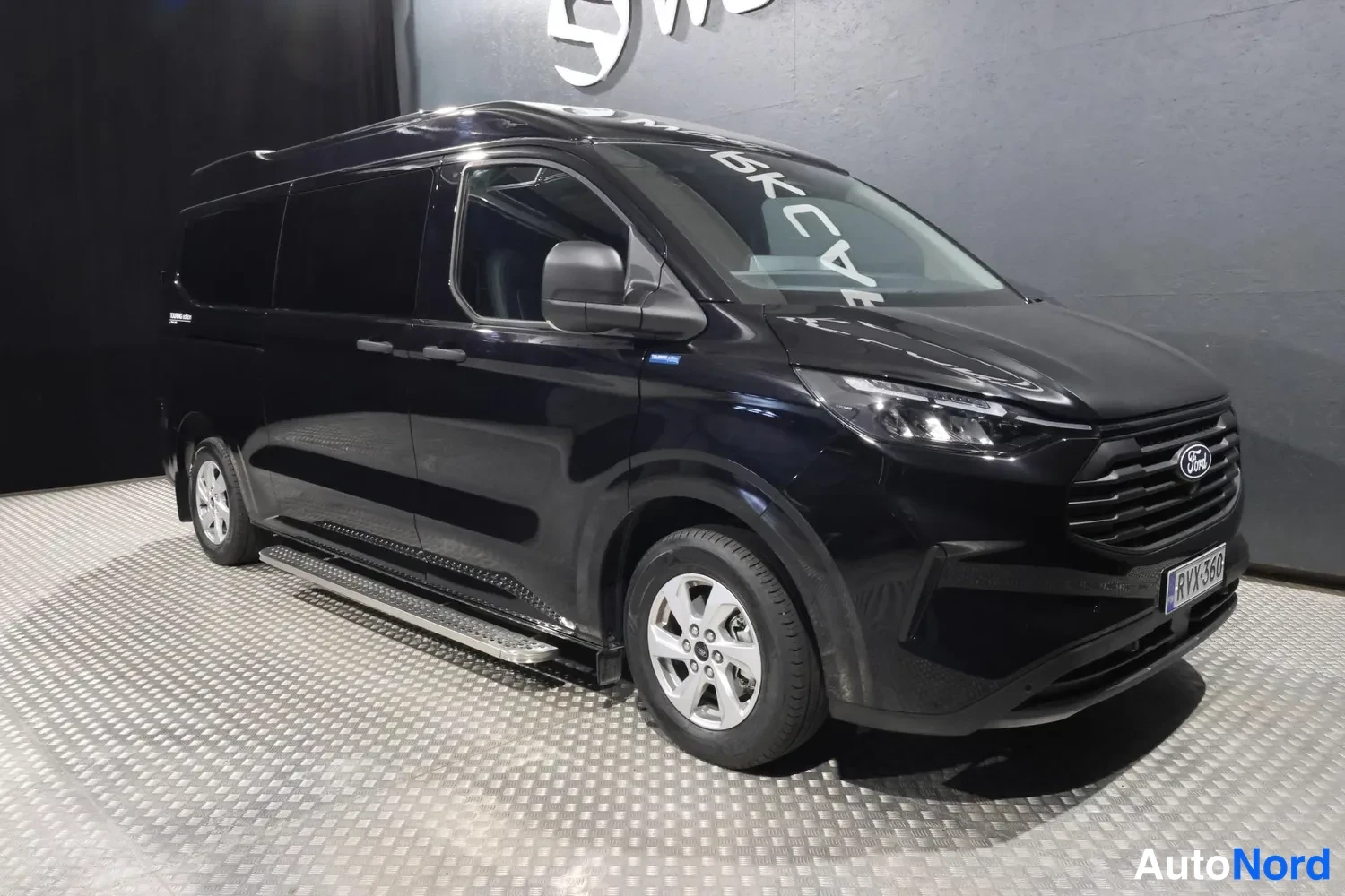 Svart Ford Transit Custom 2025, snett framifrån, fronten åt höger, bild 2