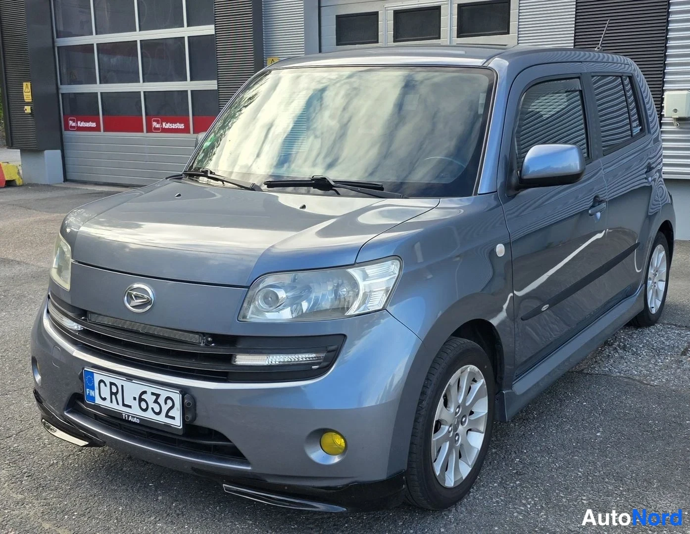 Harmaa Daihatsu Materia 2008, etuviisto, keula vasemmalle, kuva 7