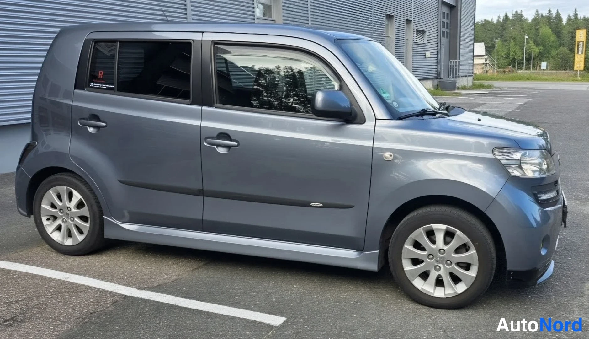 Harmaa Daihatsu Materia 2008, etuviisto, keula vasemmalle, kuva 5