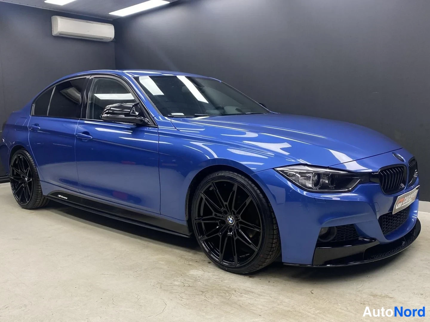Blå BMW 320i xDrive 2013, snett framifrån, fronten åt höger, bild 2