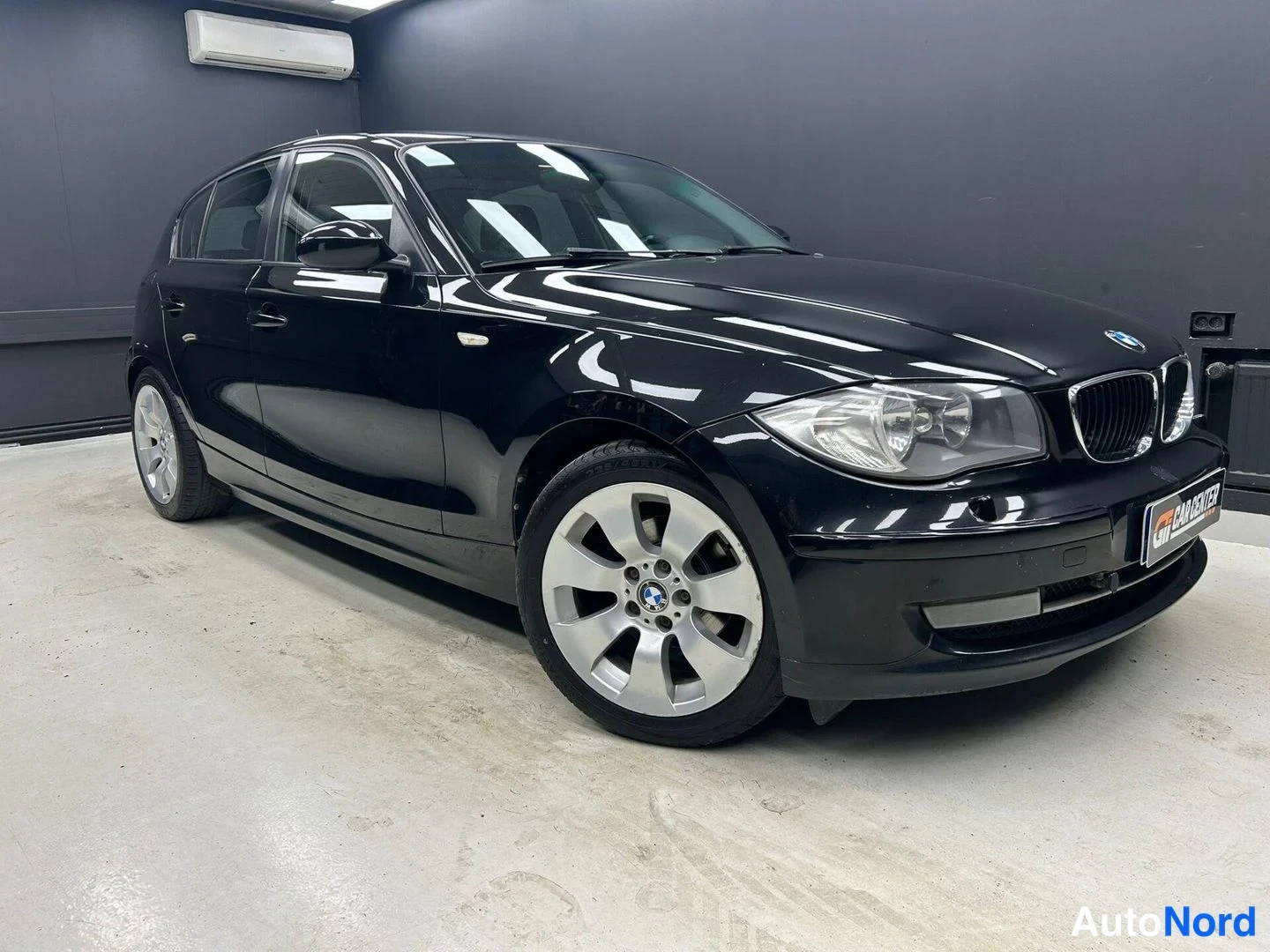 Musta BMW 116i 2009, etuviisto, keula oikealle, kuva 2