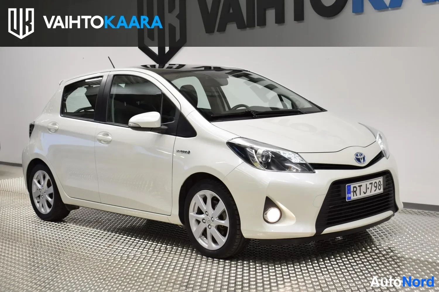 Valkoinen Toyota Yaris Hybrid 2012, etuviisto, keula oikealle, kuva 2