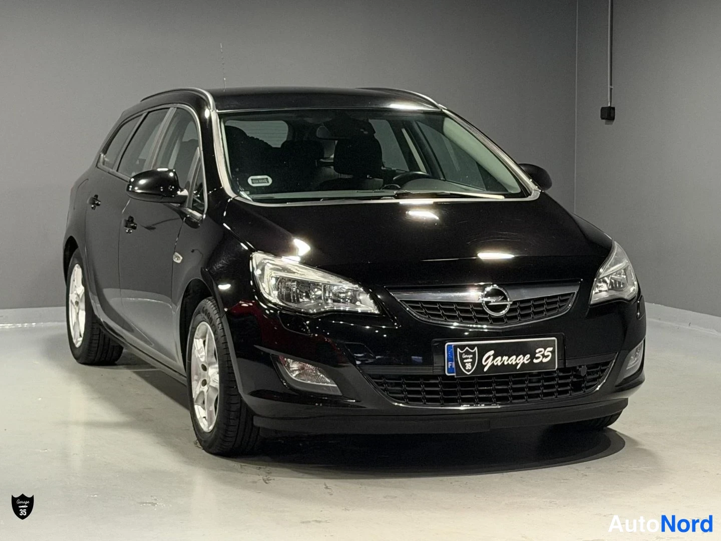 Musta Opel Astra Sports Tourer 2011, etuviisto, keula vasemmalle, kuva 2