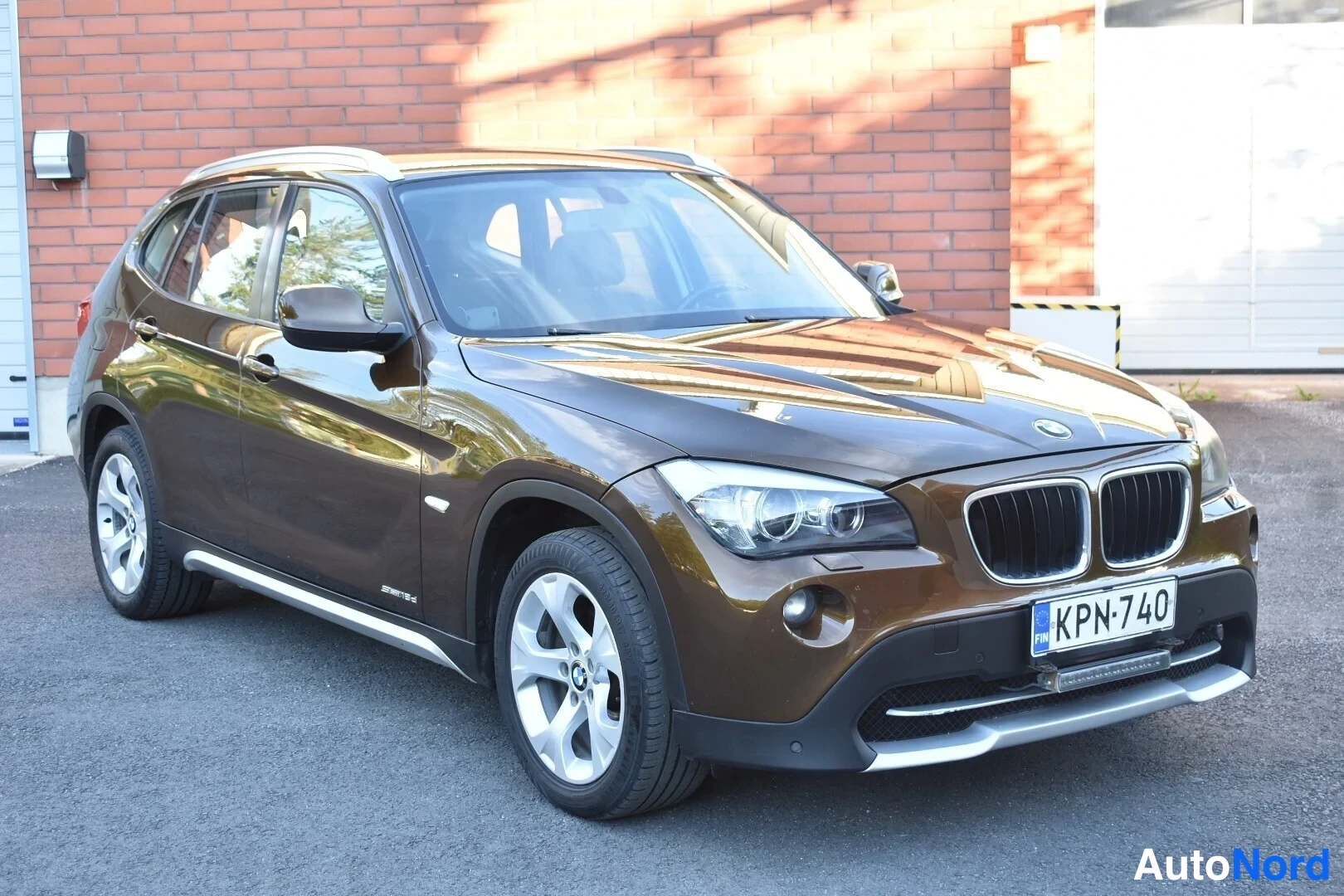 Ruskea BMW X1 2011, etuviisto, keula oikealle, kuva 3