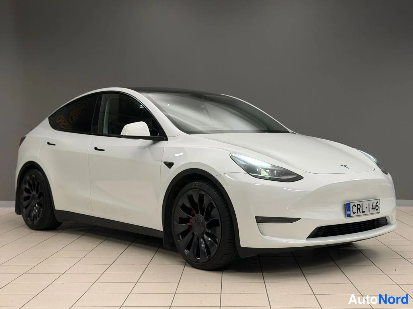 White Tesla Model Y Performance 2023, front three-quarter, nose to the right, photo 4