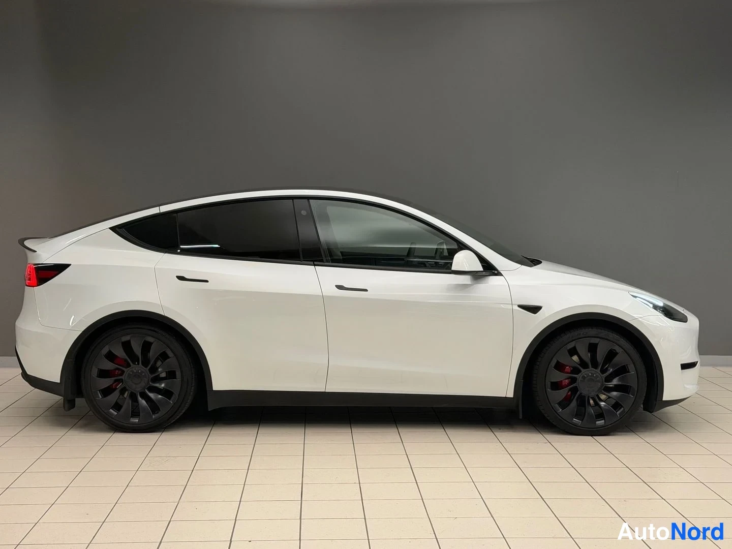 White Tesla Model Y Performance 2023, front three-quarter, nose to the right, photo 5