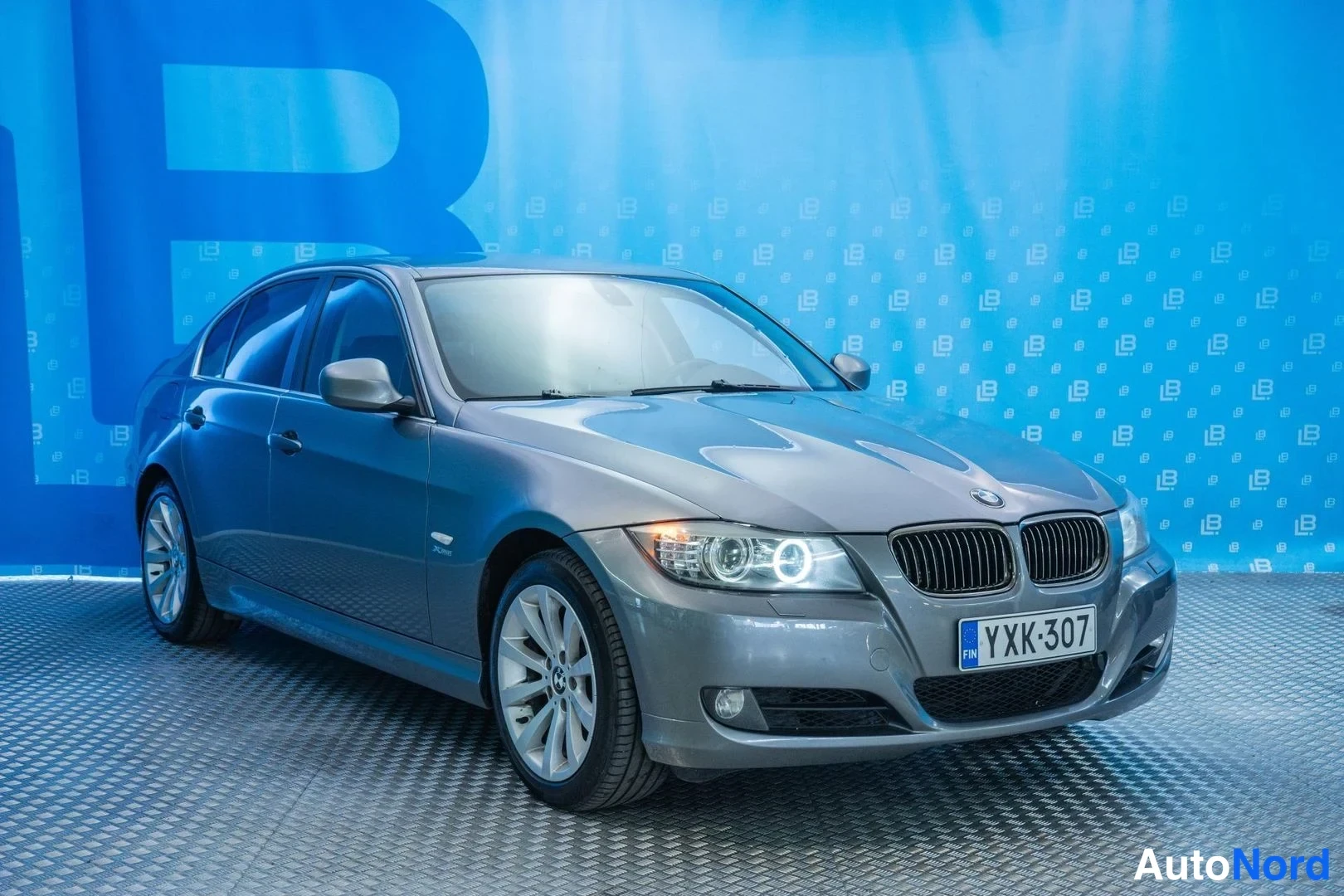 Grey BMW 325i xDrive 2009, front three-quarter, nose to the right, photo 3