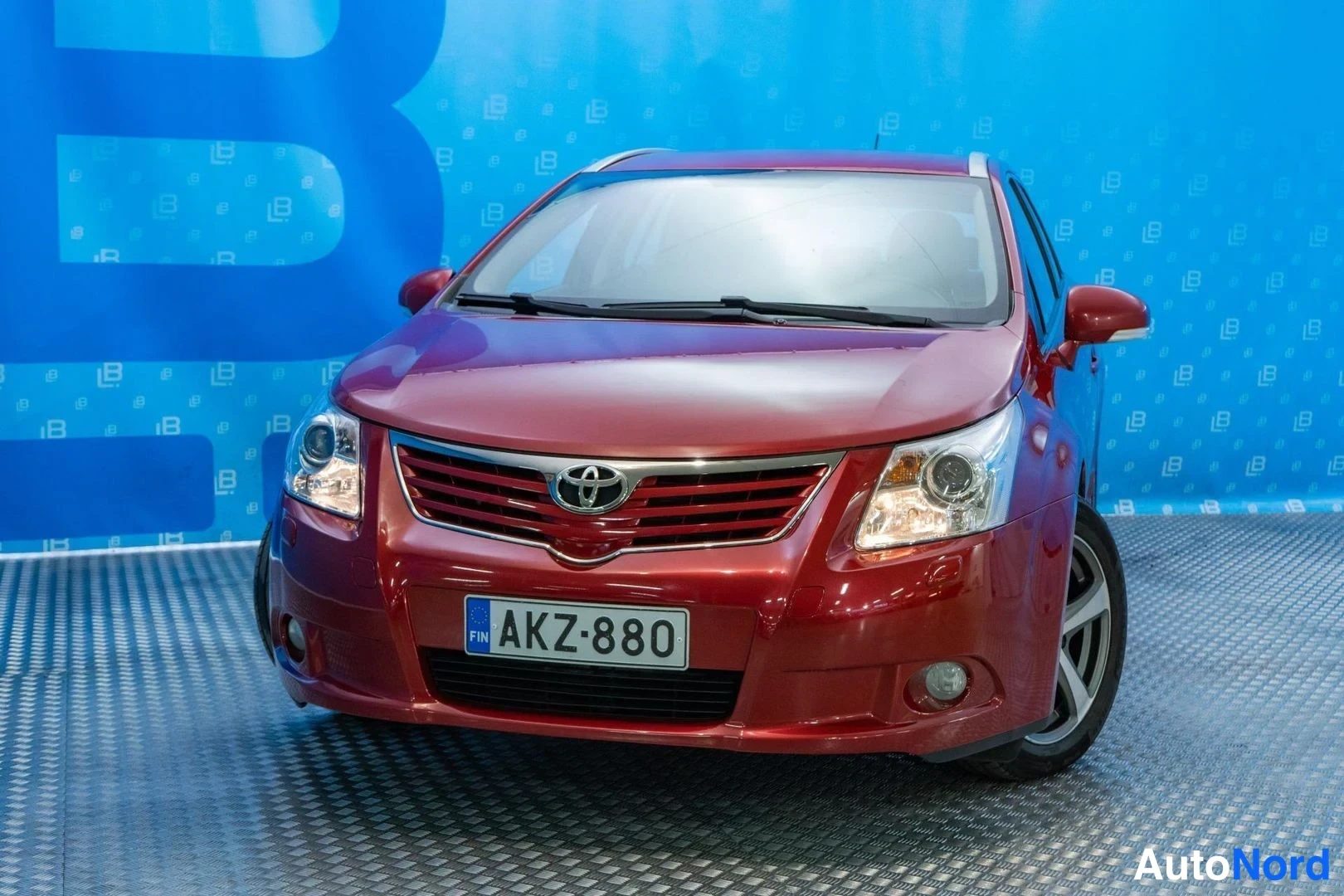 Red Toyota Avensis 2009, front three-quarter, nose to the left, photo 2