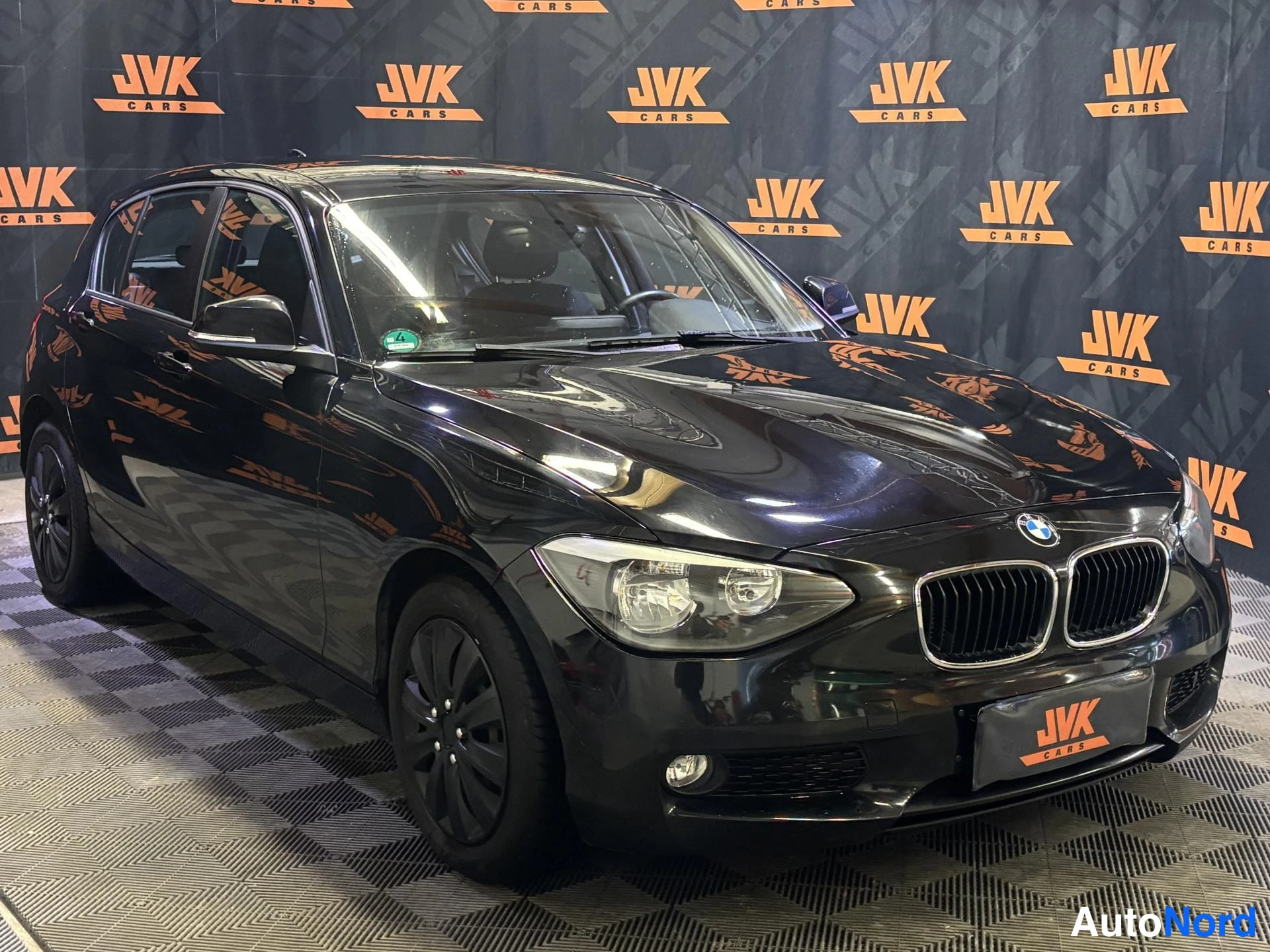 Black BMW 116i 2013, front three-quarter, nose to the right, photo 2