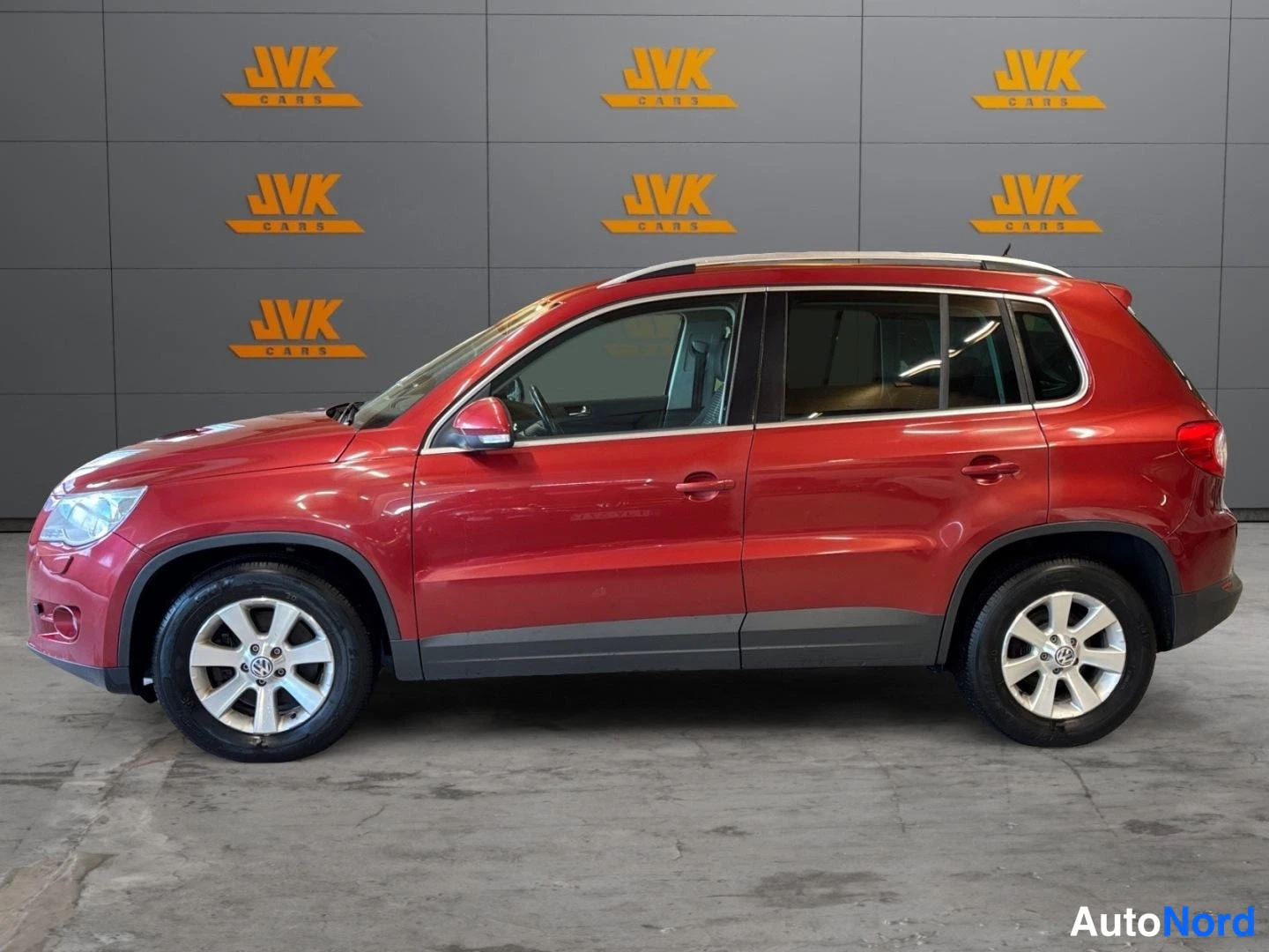 Red Volkswagen Tiguan 2009, front three-quarter, nose to the left, photo 2