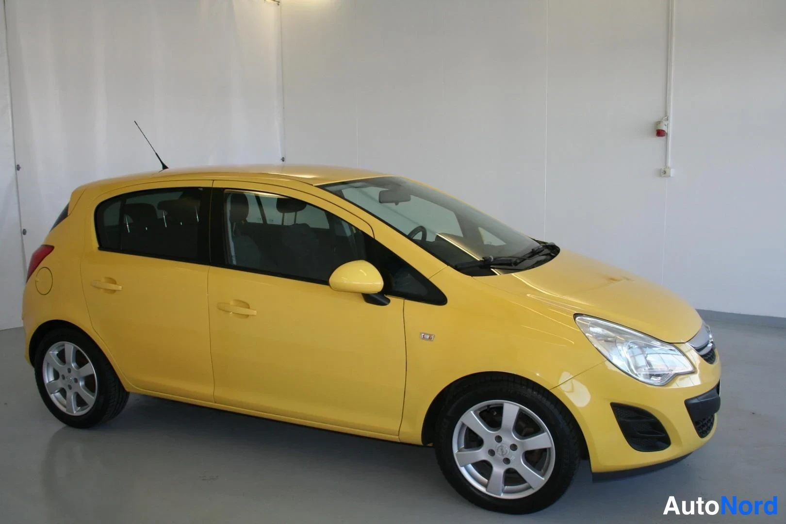 Gul Opel Corsa 2011, snett framifrån, fronten åt höger, bild 2
