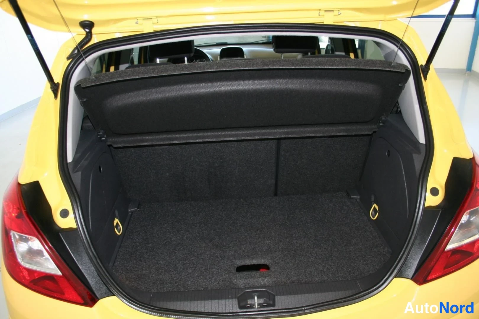 Gul Opel Corsa 2011, bagageutrymme, bild 12