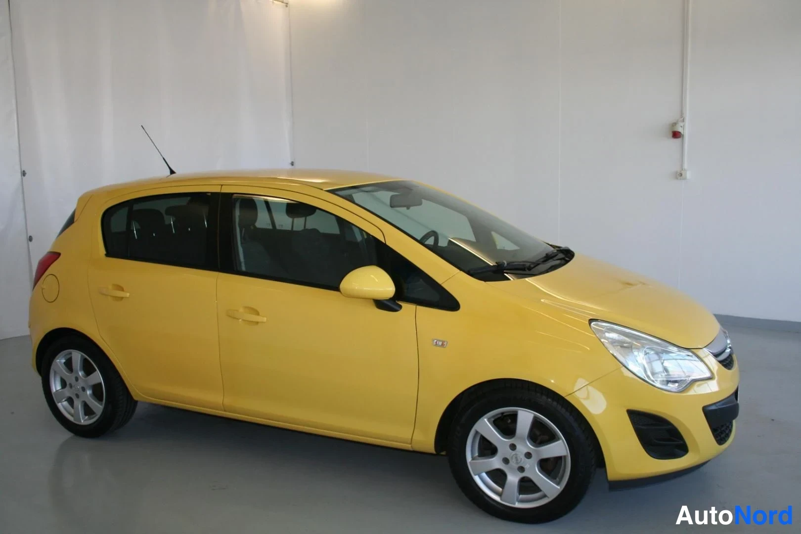Gul Opel Corsa 2011, snett framifrån, fronten åt höger, bild 3