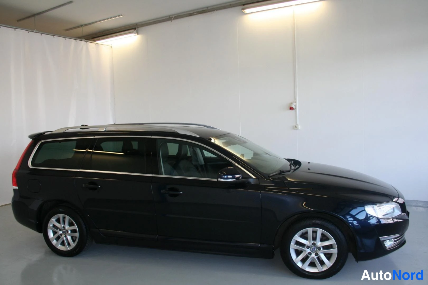 Blå Volvo V70 2016, snett framifrån, fronten åt höger, bild 3
