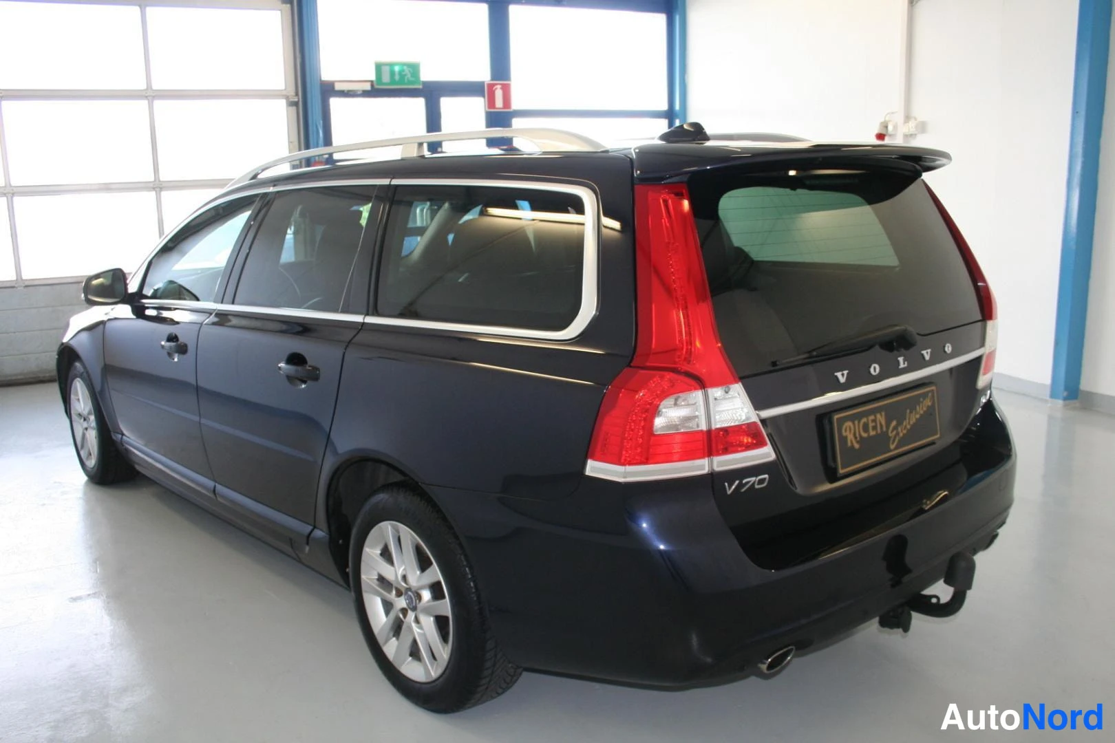 Blå Volvo V70 2016, snett bakifrån, bild 6