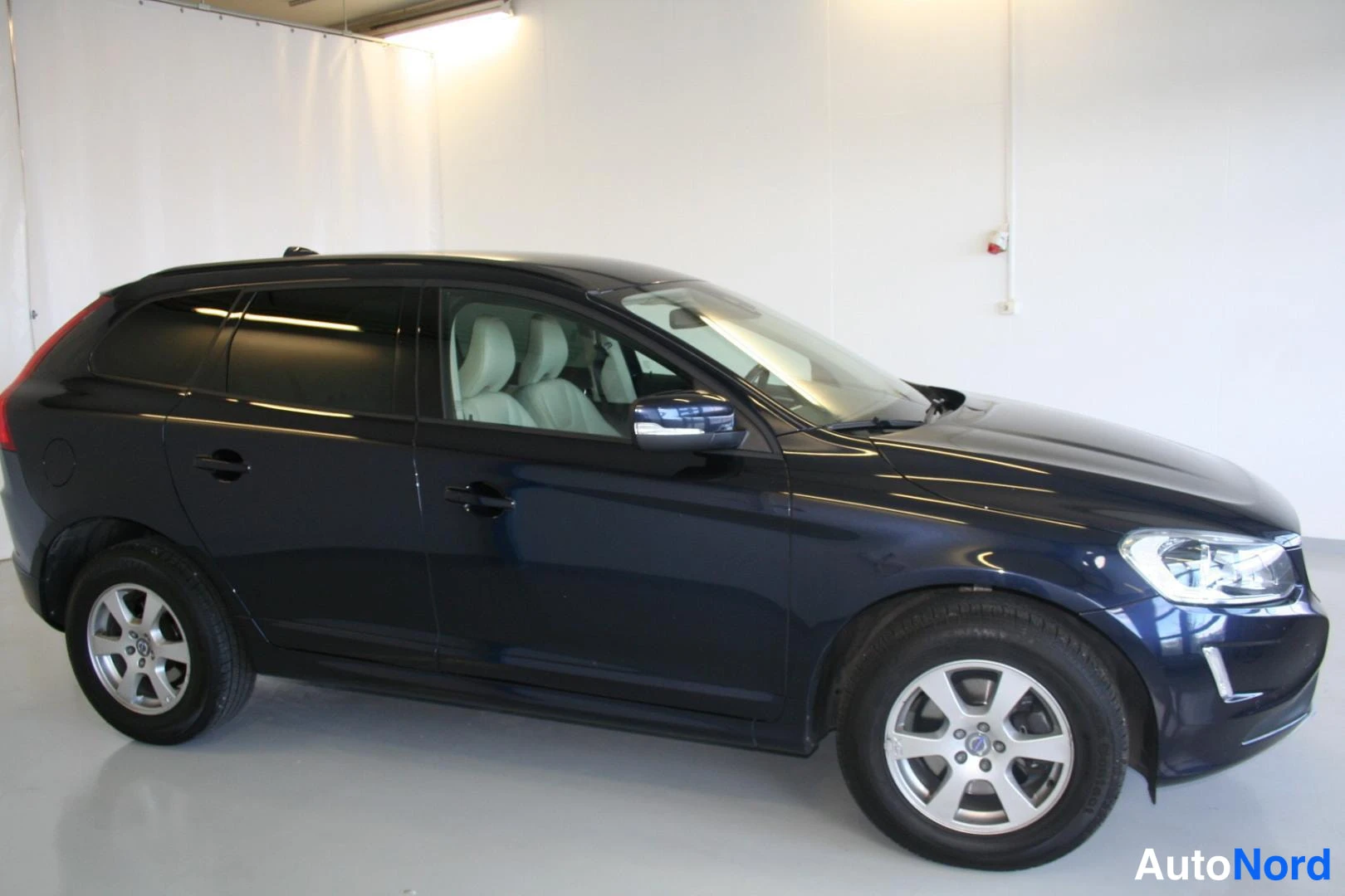Blå Volvo XC60 2016, snett framifrån, fronten åt höger, bild 3